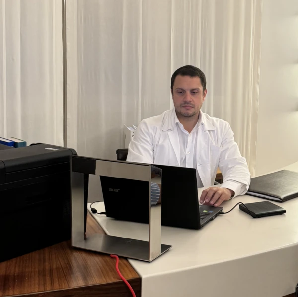 Dr. Andrea Faini, chirurgo ortopedico, al desk in studio medico durante l’attività ambulatoriale – consulenze di chirurgia ortopedica.